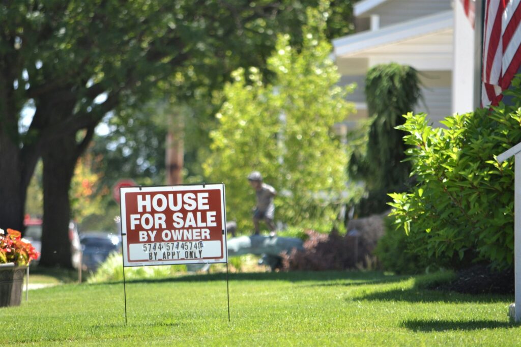 Front yard sign displaying 'House for Sale by Owner', emphasizing direct homeowner sales in residential real estate market.